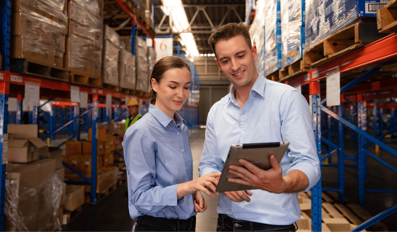 People stood in warehouse look at ipad